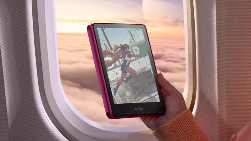 A hand holding a tablet with a color display against the window of an airplane.