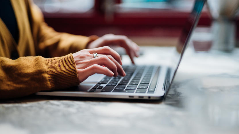 Side view of female hand typing on laptop keyboard. Freelancer working with laptop at cafe. Technology and flexible working.