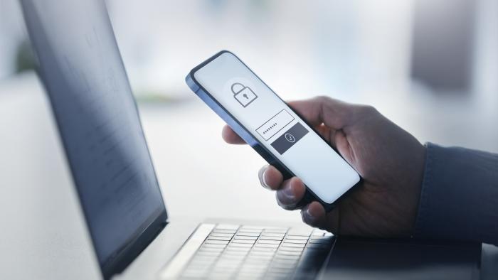 Man holding smart phone with data security on display at office