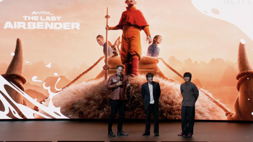 Three people on a stage with the poster that says "Avatar the Last Airbender" in the background.