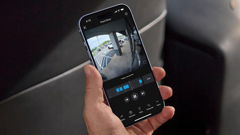 Image of a smartphone showing the Ring app with a 24/7 video feed on its display.