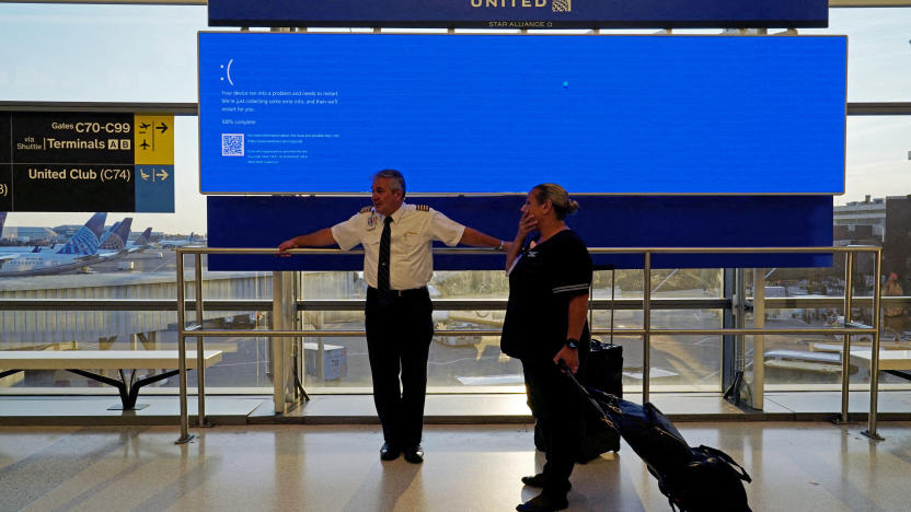 United Airlines employees wait by a departures monitor displaying a blue error screen, also known as the “Blue Screen of Death” inside Terminal C in Newark International Airport, after United Airlines and other airlines grounded flights due to a worldwide tech outage caused by an update to CrowdStrike's "Falcon Sensor" software which crashed Microsoft Windows systems, in Newark, New Jersey, U.S., July 19, 2024. REUTERS/Bing Guan     TPX IMAGES OF THE DAY