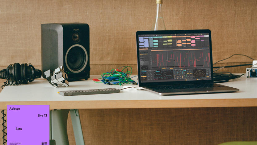 A laptop running Ableton Live 12 alongside a portable synth and a desktop monitor speaker.