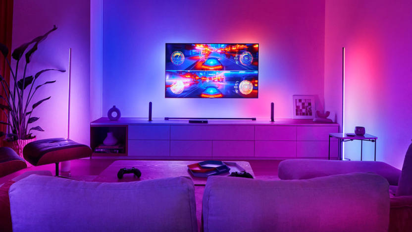 A living room with blue, red and purple lighting to match the video game on the TV screen.