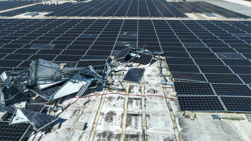 Broken down photovoltaic solar panels destroyed by hurricane Ian winds mounted on industrial building roof for producing green ecological electricity. Consequences of natural disaster.