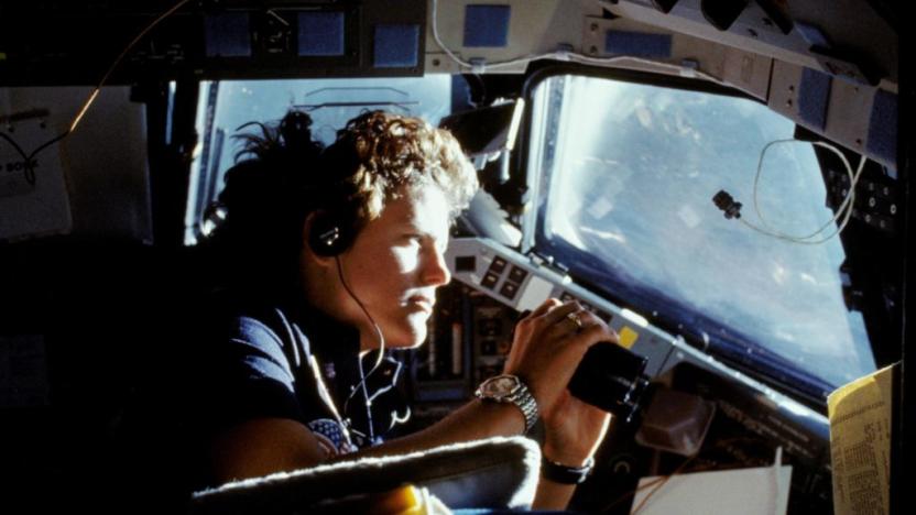 41G-11-027 (14 Oct. 1984) --- Kathryn D. Sullivan, 41-G mission specialist, uses a pair of binoculars to do some magnified viewing through the forward cabin windows of the Earth-orbiting space shuttle Challenger. The 35mm frame was part of the first photographic release from the eight-day 41-G mission on Oct. 14, 1984. Photo credit: NASA